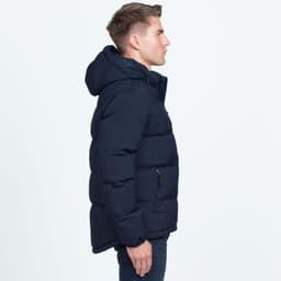 A side view of a navy blue puffer jacket featuring a hood and a logo. The jacket has a padded design.