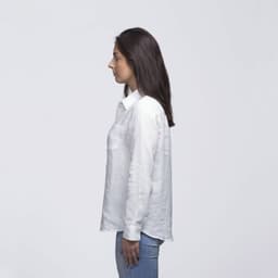 A white linen button-up shirt displayed on a model from the side, featuring a pocket and a collar.