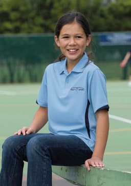 A light blue polo shirt with dark accents, featuring a logo, worn by a smiling girl seated on a court.