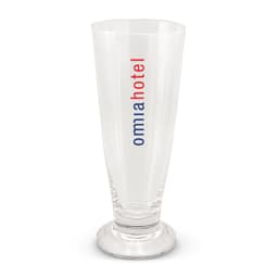 A clear beer glass with a tall, slender design and a base, featuring a logo in red and blue.