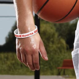 A white silicone wristband with a logo, worn on a hand holding a basketball.