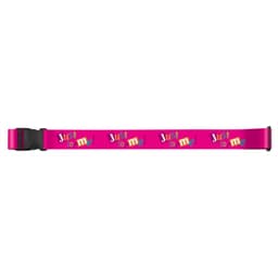 A pink luggage strap featuring a playful design with the words "Just lo me!" and a black buckle.