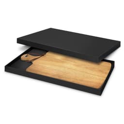 A wooden serving board in a black box, featuring a leather loop for hanging.