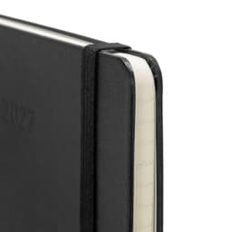 A black Moleskine 2027 planner with a textured cover and an elastic band, featuring rounded corners and cream pages.