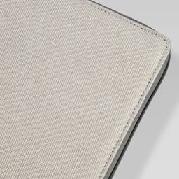 A textured beige cover of a portable drawing set with a black edge. Features a branding logo.