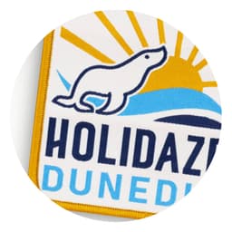 A woven patch featuring a yellow and blue design with a sun and a playful seal silhouette.