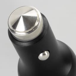 A black car charger with a metallic tip and a small button, featuring a logo on its surface.