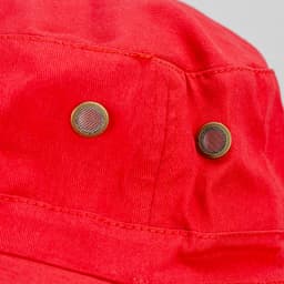 A close-up of a red wide brim hat featuring metal ventilation eyelets and a textured fabric.