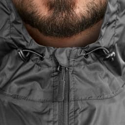 A close-up of a black windbreaker with a hood and adjustable drawstrings around the neckline.