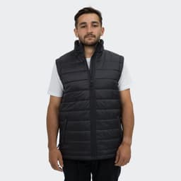A man wearing a black puffer vest with a high collar and zippered front, featuring side pockets.