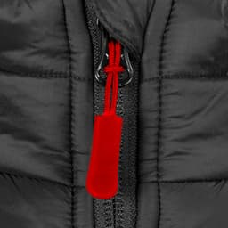 A close-up of a black puffer vest, featuring a zip with a red pull tab. The vest has quilted detailing.