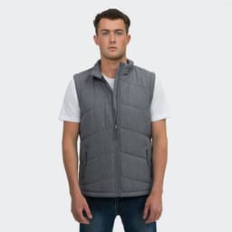A grey puffer vest displayed on a model wearing a white T-shirt and jeans. The vest features a branding logo.
