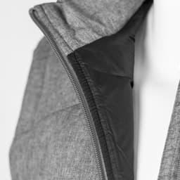 A grey puffer vest with a black interior, featuring a zippered front and a hood. The vest has a logo on it.