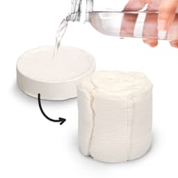 A compressed white towel next to a hand pouring water from a clear drink bottle. The towel appears in a circular shape.