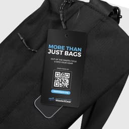 A black sling bag with a textured surface and a tag featuring a logo and QR code.