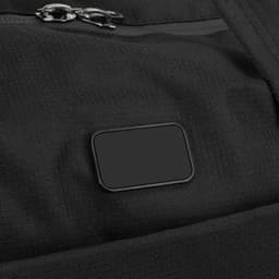 A black duffle bag featuring a zip closure and a branding tag. The material has a textured appearance.