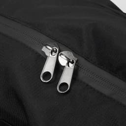 A black duffle bag featuring dual metallic zippers and a textured fabric surface. It has a logo on the material.