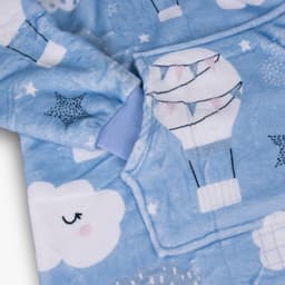 A light blue blanket hoodie featuring hot air balloons, clouds, and stars, with a front pocket and soft fabric.