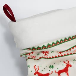 A festive Christmas stocking in white, red, and green, featuring a soft top and decorative patterns.
