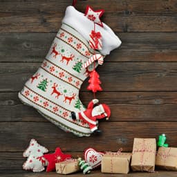 A full-colour Christmas stocking features festive designs of reindeer, trees, and ornaments, hanging against a wooden backdrop.