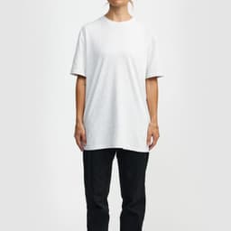 A white essential T-shirt, with short sleeves, displayed on a model, paired with black trousers. The shirt has a branding logo.