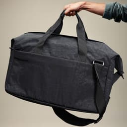 A black duffle bag with dual handles and a shoulder strap, featuring a front pocket and a brand logo.