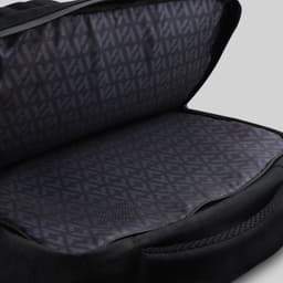 An open black backpack revealing a patterned inner lining and spacious compartment. The bag has a sleek design.