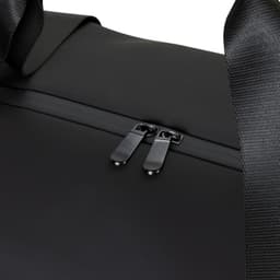 A black soft-touch duffle bag featuring a zip closure and fabric handles, with a subtle logo.