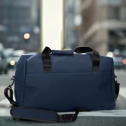 A navy blue soft-touch duffle bag with black handles and a shoulder strap, featuring a logo.