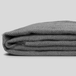 A folded grey keepsake throw blanket with a textured pattern, featuring a subtle stripe design.