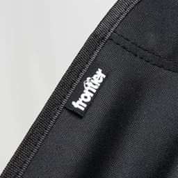 A black fabric showing stitching and a logo tag for a folding chair.