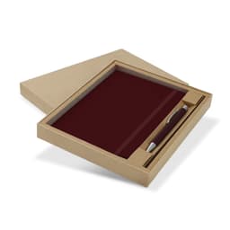 A maroon notebook and pen gift set displayed in a cardboard box. The set features a sleek pen alongside the notebook.