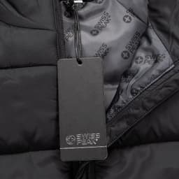 A black unisex puffer vest with a zip and an inner lining featuring a branding logo. A tag is attached.