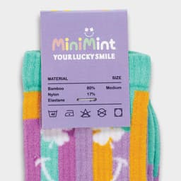 A pair of multicoloured knitted bamboo socks in purple, green, yellow, and white, with a tag displaying branding and care instructions.