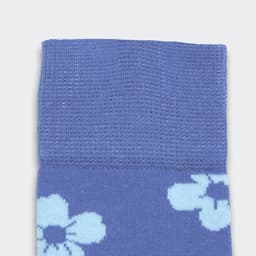 Knee-high socks in a blue hue featuring floral patterns, with a textured upper section and a smooth lower section.