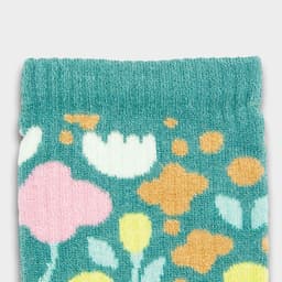 A close-up of light teal kids' socks featuring a colourful floral pattern in pink, yellow, and white.