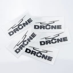 Five black stickers featuring the word "DRONE," set against a clear background, showcasing a simple design.