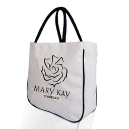 A large, two-tone calico shopper bag in cream with navy blue handles and trim, featuring a logo on the front.