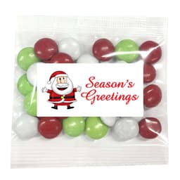 A festive pack of chocolate-coated beans in red, green, and white, featuring a Christmas-themed label with a logo.