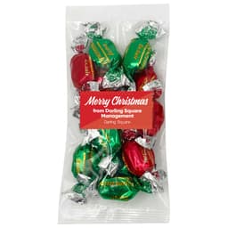 A pack of Christmas toffees with red and green wrappers, featuring silver foil. The pack has a logo on it.