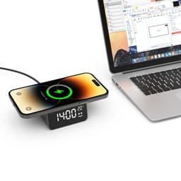 A wireless charger with a clock displays, featuring a sleek design and a mobile phone charging on top, in black and silver.