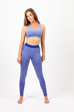 A model wearing seamless leggings in a vibrant purple hue, paired with a matching crop top. The image features a logo.
