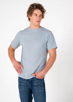 A men's slim fit t-shirt in light blue, featuring short sleeves and a round neckline, paired with blue jeans.