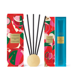 A scented diffuser set featuring a gold base, black reeds, and decorative packaging in vibrant colours.