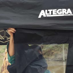 A black gazebo wall with a clear section, featuring an attached logo at the top.