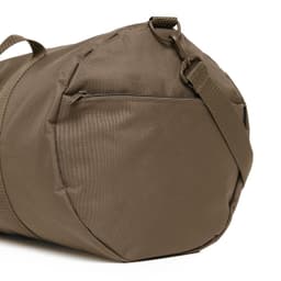 A brown duffel bag with a strap and a zipper pocket on the side, featuring a simple, sleek design.