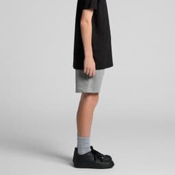 Youth stadium shorts in grey, featuring a logo, paired with a black t-shirt and black sneakers.