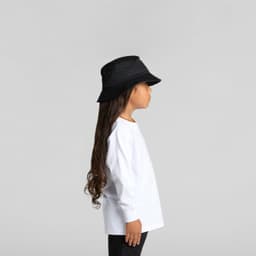 A child in a white long-sleeve tee and a black bucket hat, standing in profile against a neutral background.