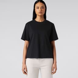 A black T-shirt displayed on a model, featuring a relaxed fit and short sleeves, without any visible logos.