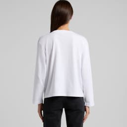A white long-sleeve t-shirt with a simple design and a logo on the back, styled with black pants.
